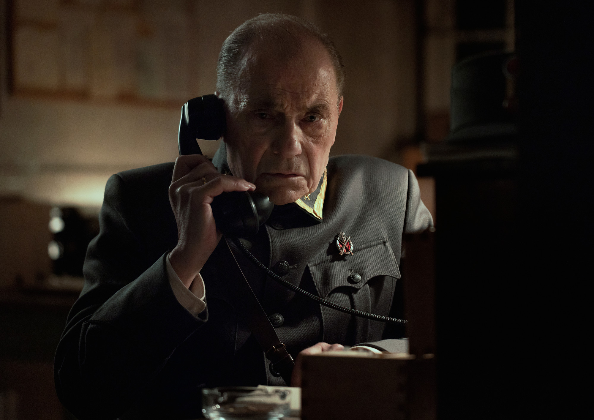 Foto. En mann i uniform snakker i telefonen.