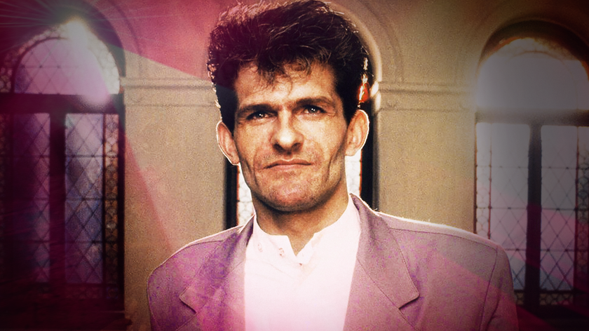 Foto. Portrett av en mann med mørkt hår. Buende vinduer i bakgrunnen som slipper inn lys.